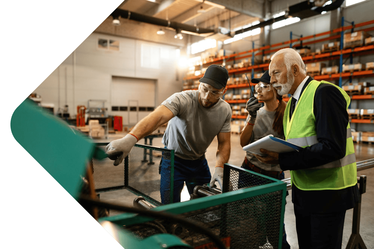 Two manufacturing staff showing a health and safety person a machine