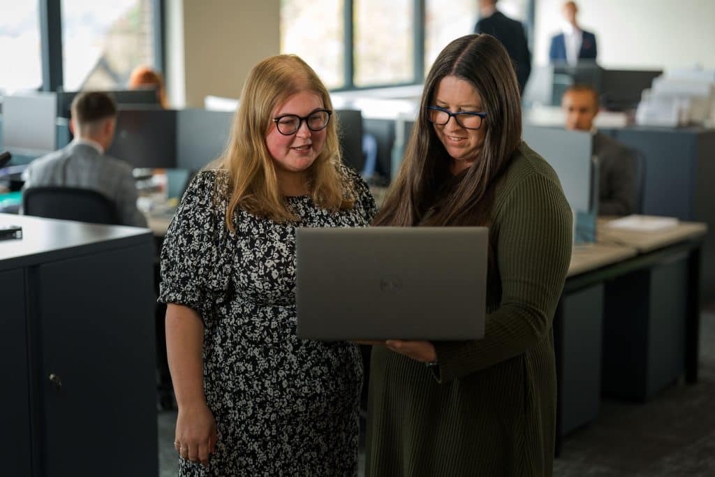 Charlotte Owen and Claire Pass working on a laptop
